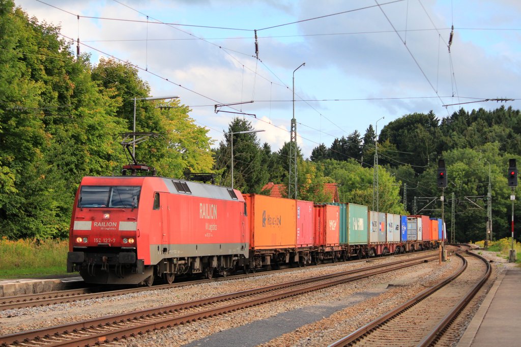 152 127-7 von  Railion  durchfhrt am 16. August 2012, mit einem Containerzug  den Bahnhof von Assling in Richtung Rosenheim.