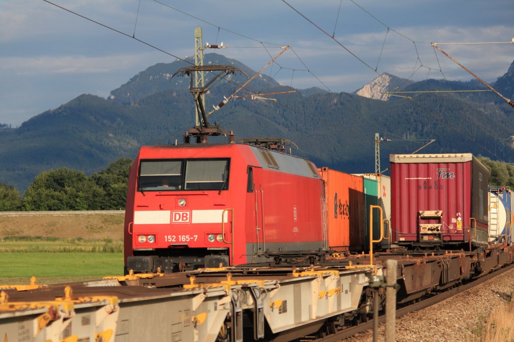 152 165-7 etwas verdeckt von einem entgegenkommenden Gterzug bei Bernau am Chiemsee, am 9. August 2012.