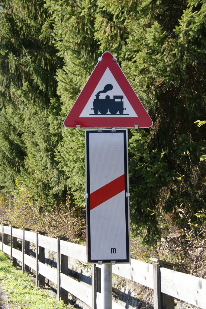 Warnschild auf einen unbeschrankten Bahnbergang mit alter Dampflok.
Aufgenommen am 30. Oktober 2011 in der Nhe von St. Johann/Tirol.