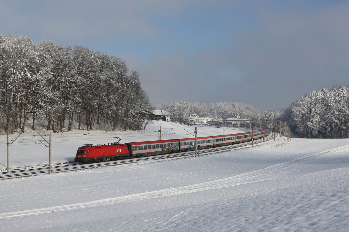 1116 087 war mit dem  EC 114  am 13. Januar 2024 bei Axdorf im Chiemgau in Richtung Mnchen unterwegs.