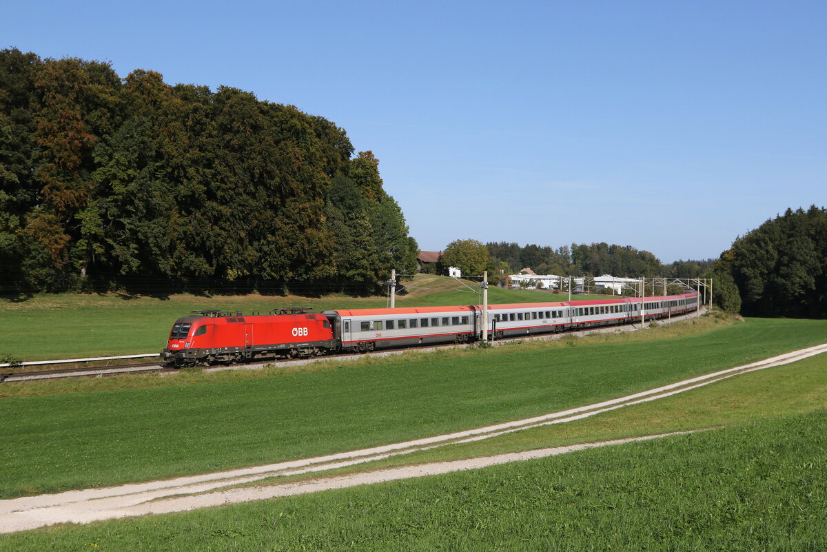 1116 112 war am 11. Oktober 2023 bei Axdorf im Chiemgau mit einem  EC  in Richtung Mnchen unterwegs.