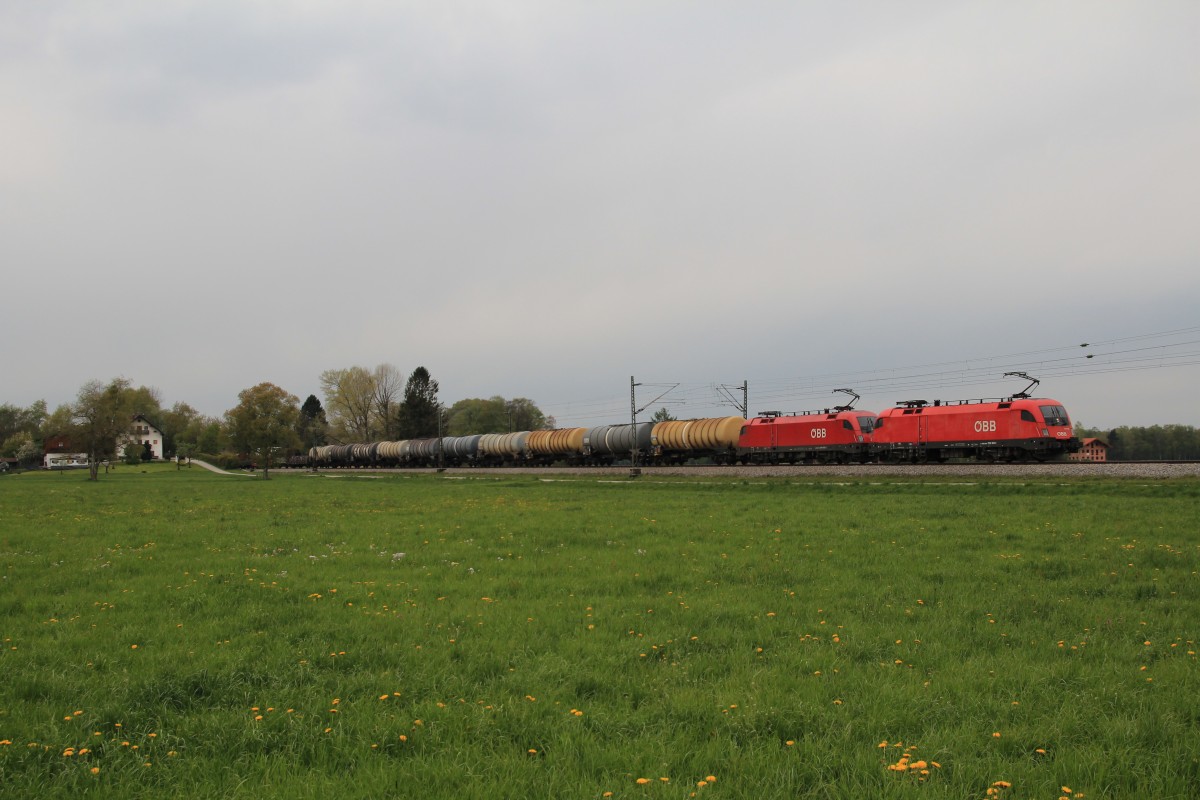 1116 180-1 und 1016 xxx mit einem gemischten Gterzug am 18. April 2014 bei bersee am Chiemsee.
