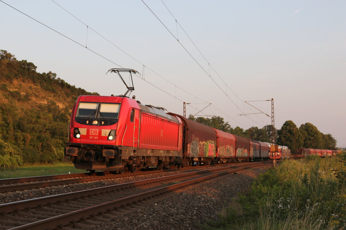 187 165 mit einem gemischten Gterzug im letzten Licht des 23. Juli 2021 bei Himmelstadt im Maintal.