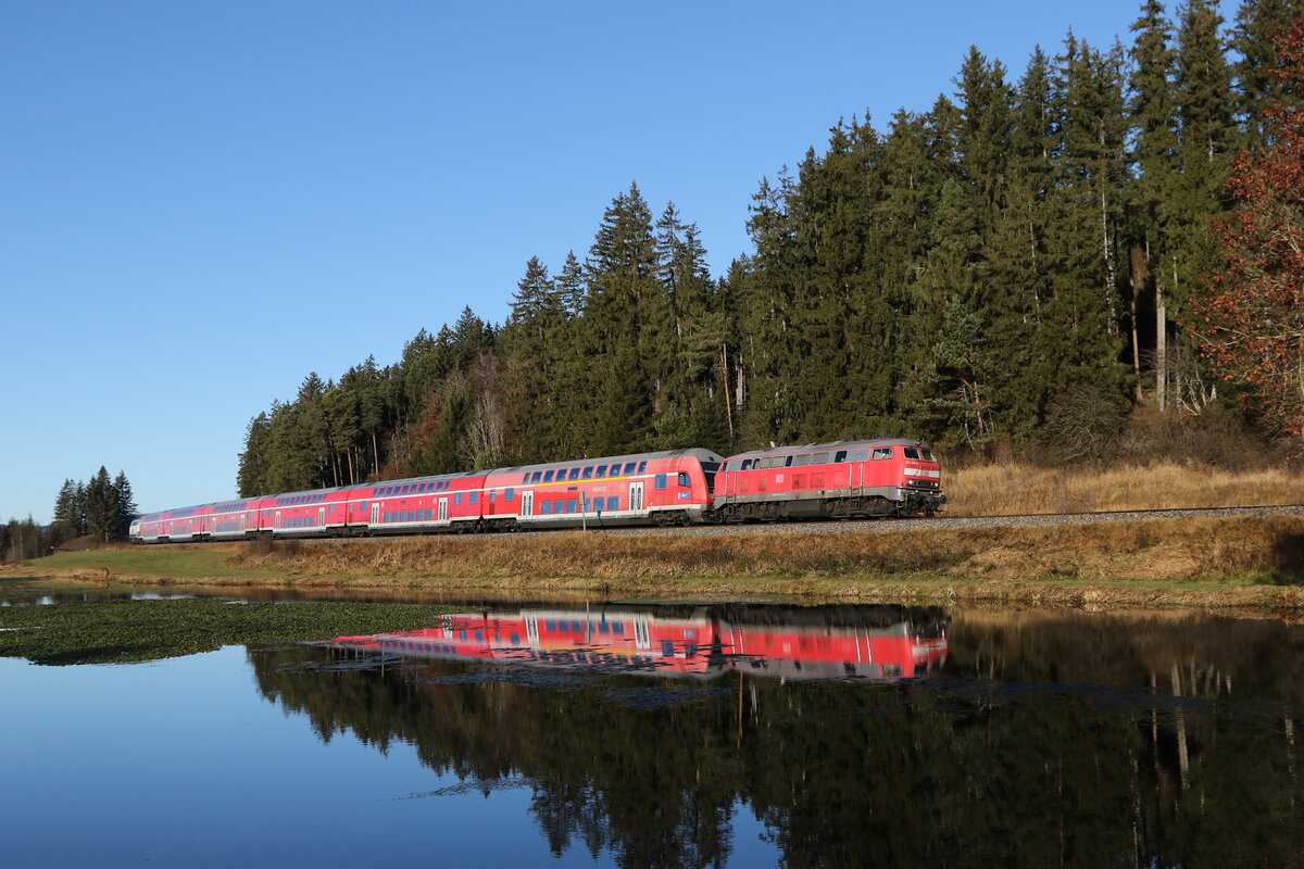 218 411 war am 21. November 2021 mit einem Doppelstock-Regionalzug bei Ruderatshofen in Richtung Mnchen unterwegs.