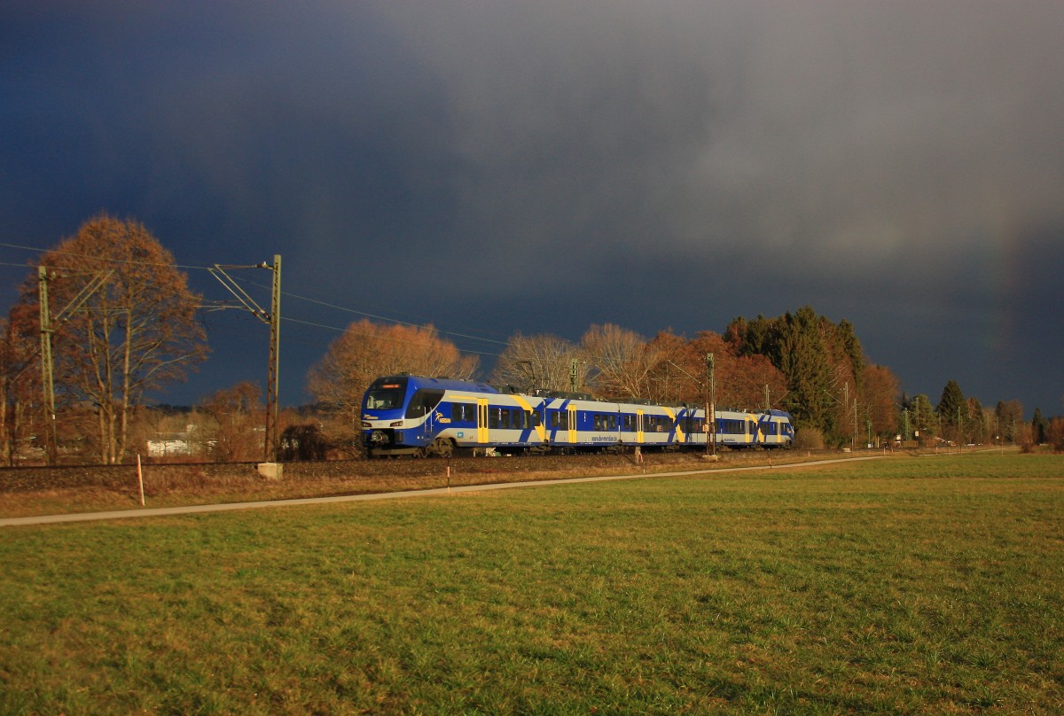 Am 21. Februar 2014 nähert sich dieser  Meridian -Triebwagen im Licht der aufgehenden Sonne dem Bahnhof von Prien am Chiemsee.
