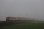 Im dichten Nebel verschwindet der Regionalzug von Mnchen nach Salzburg.