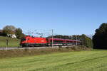 1116 062 mit einem  Railjet  aus Salzburg kommend am 28. Oktober 2023 bei Axdorf im Chiemgau.