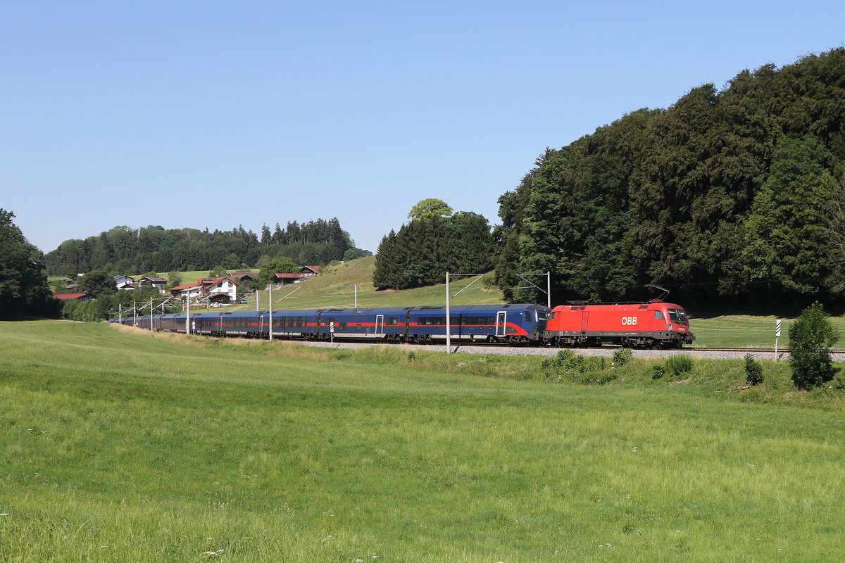 1016 010 war am 26. Juni 2026 mit einer  Nightjet-Garnitur  bei Axdorf im Chiemgau in Richtung Salzburg unterwegs.