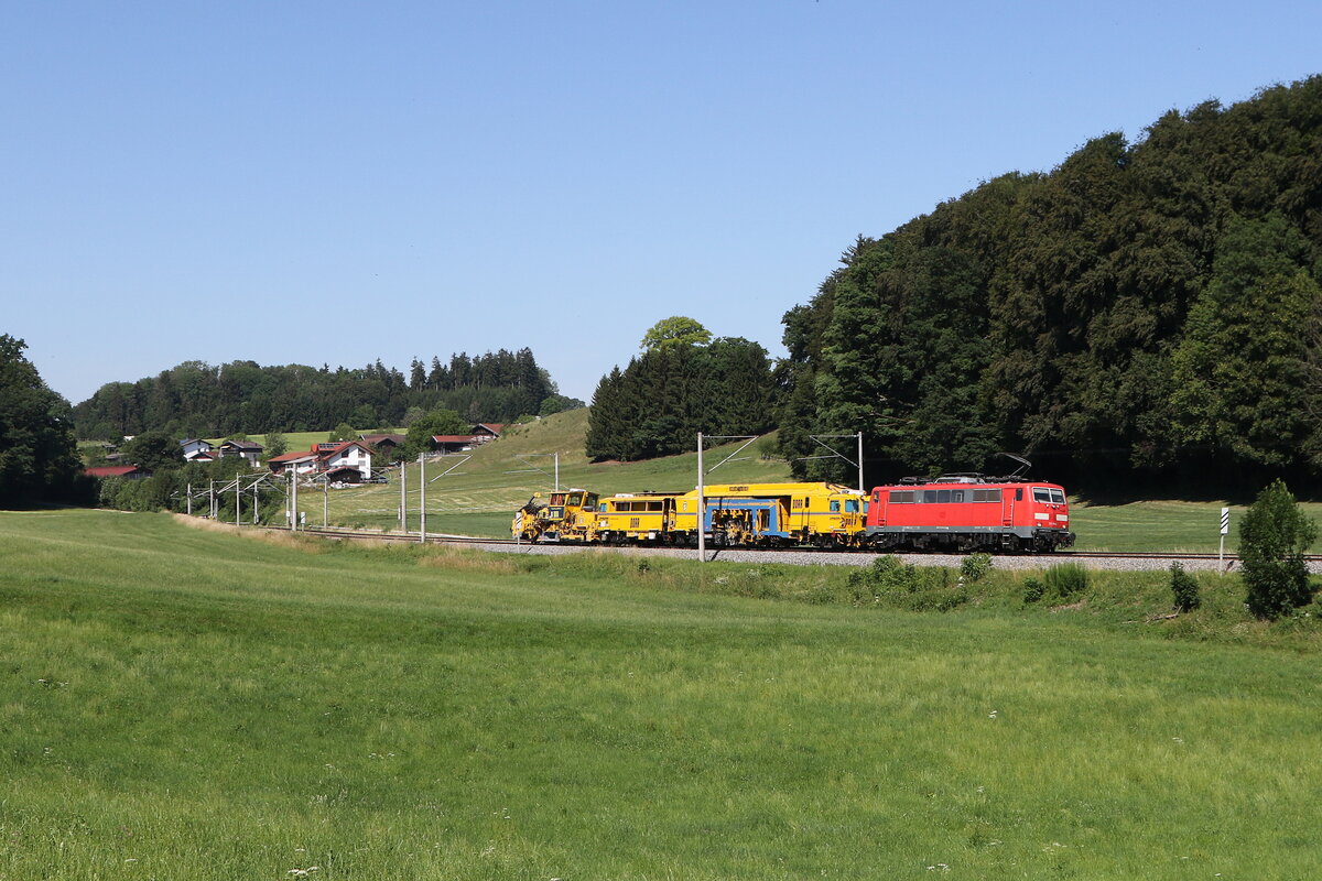 111 094 unterwegs mit einem kurzen Bauzug in Richtung Freilassing. Aufgenommen am 26. Juni 2026 bei Axdorf im Chiemgau.