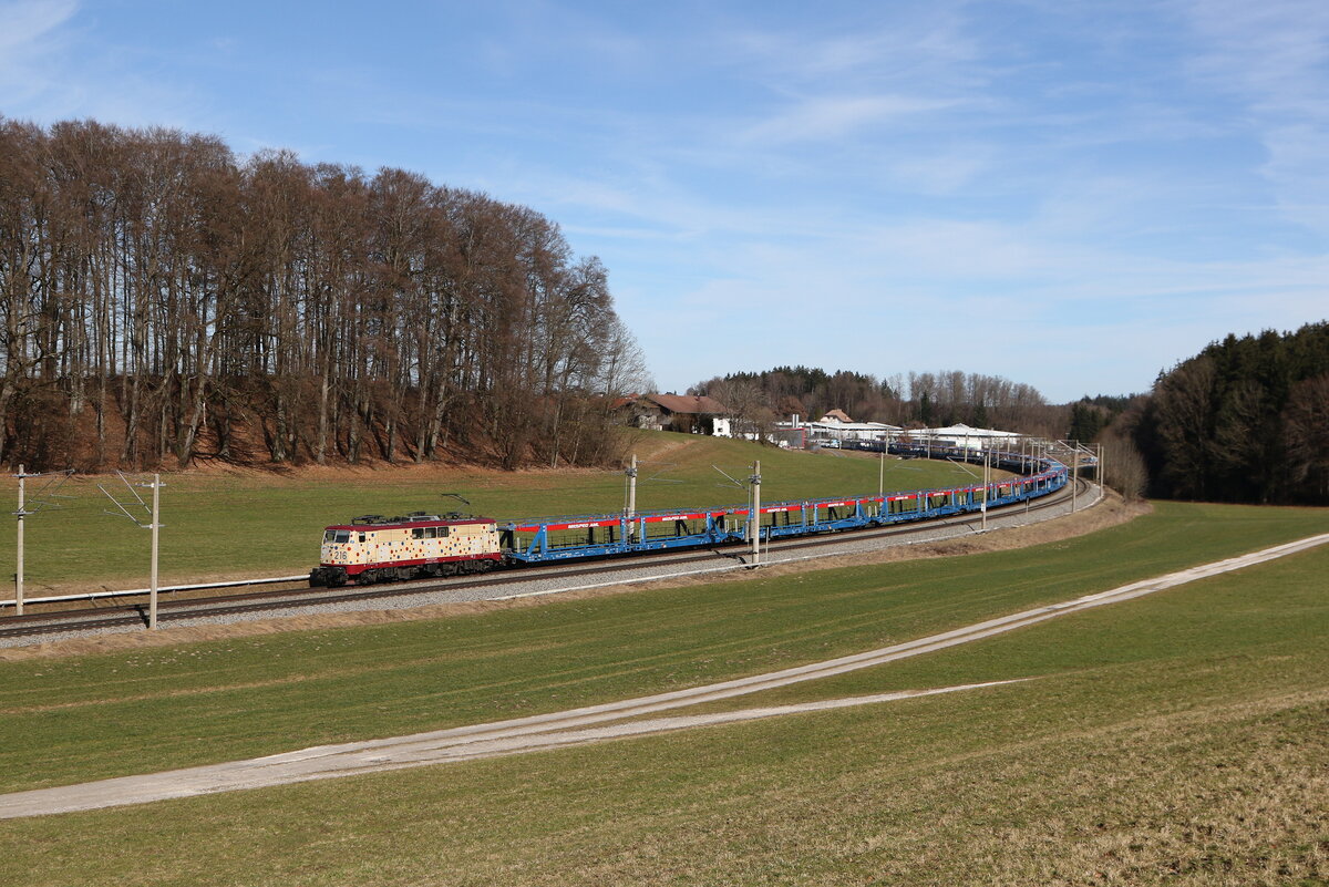 111 216 war am 26. Februar 2026 mit einem leeren Autozug bei Axdorf im Chiemgau in Richtung M�nchen unterwegs.