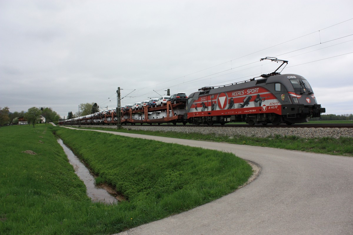 1116 138 ist am 28. April 2013 mit einem  VW-Autozug  bei Übersee in Richtung Salzburg unterwegs.