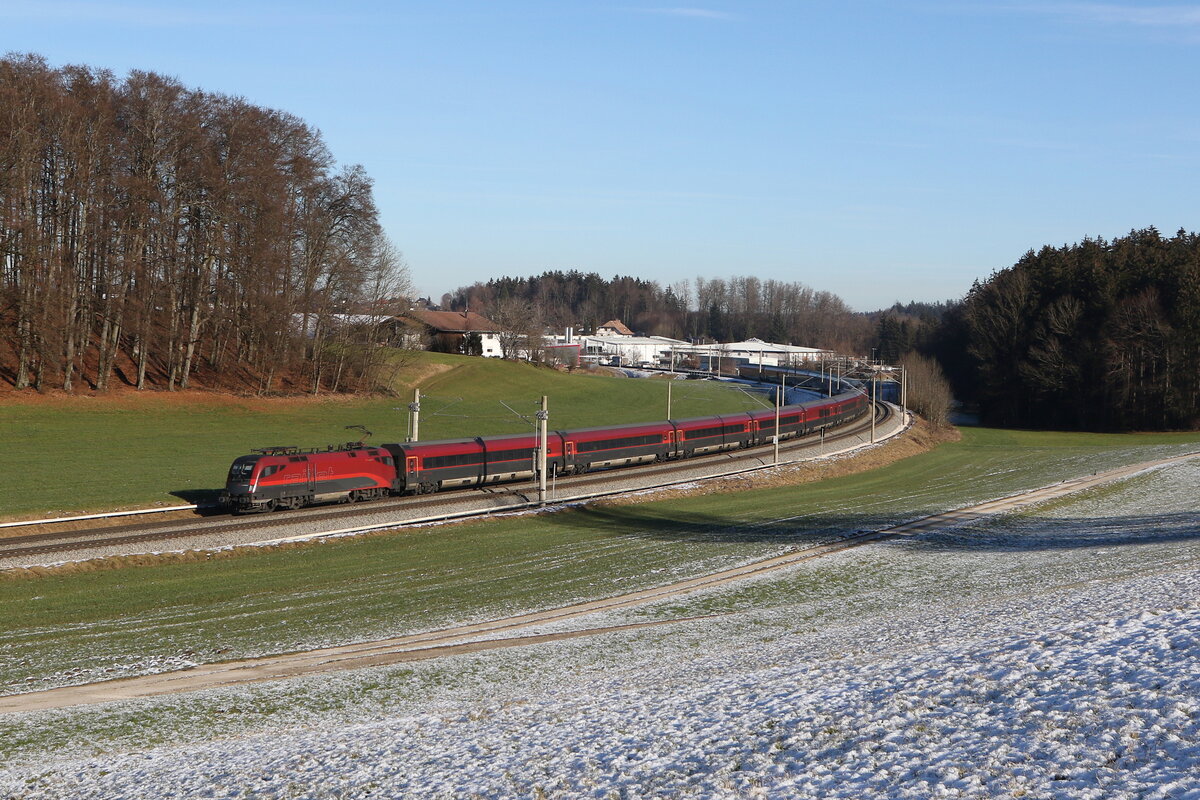 1116 220 mit einem  Railjet  aus Salzburg kommend am 27. Dezember 20224 bei Axdorf.