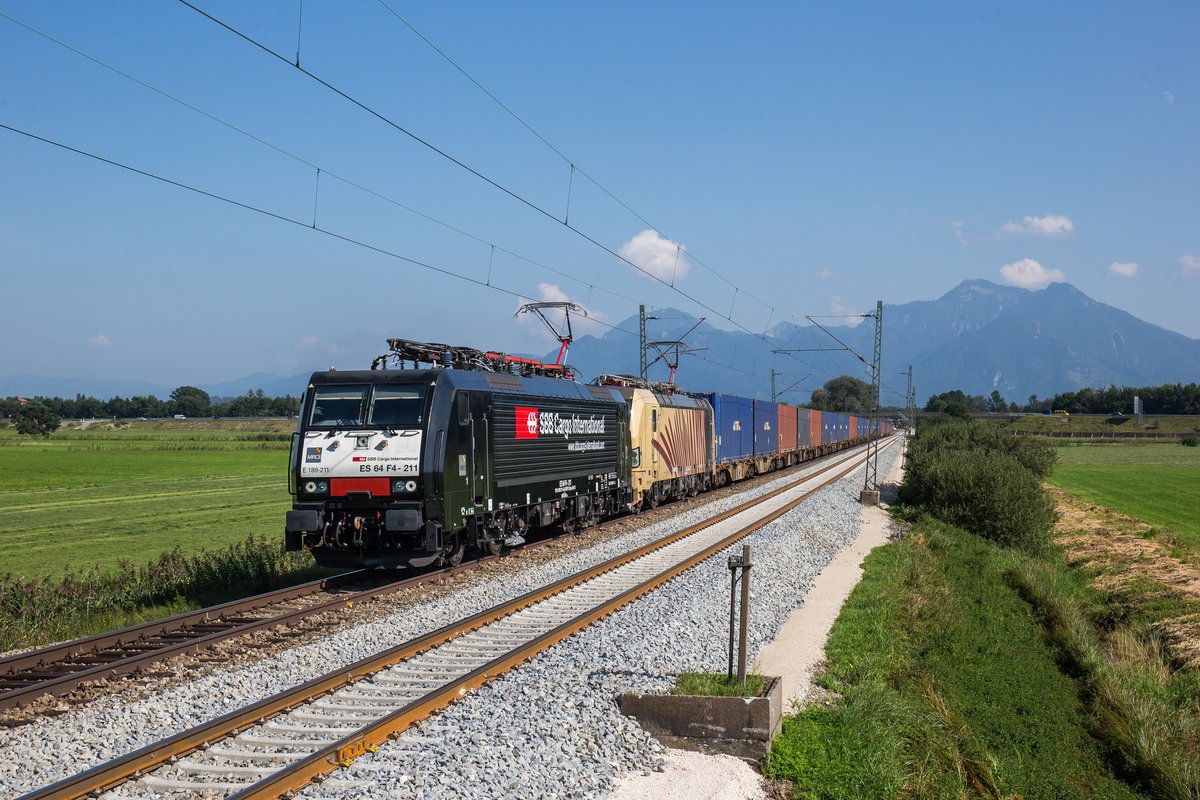 189 211 von  SBB Cargo  und 193 777 von  Locomotion  mit einem Containerzug am 29. August 2017 bei Bernau am Chiemsee.